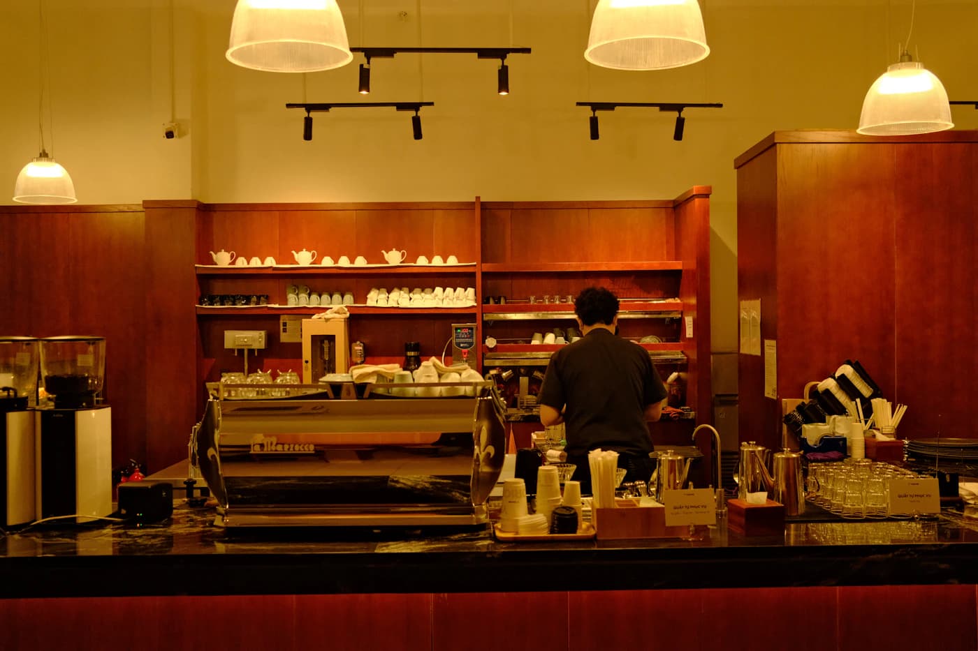 Barista working behind an espresso counter in a coffee shop