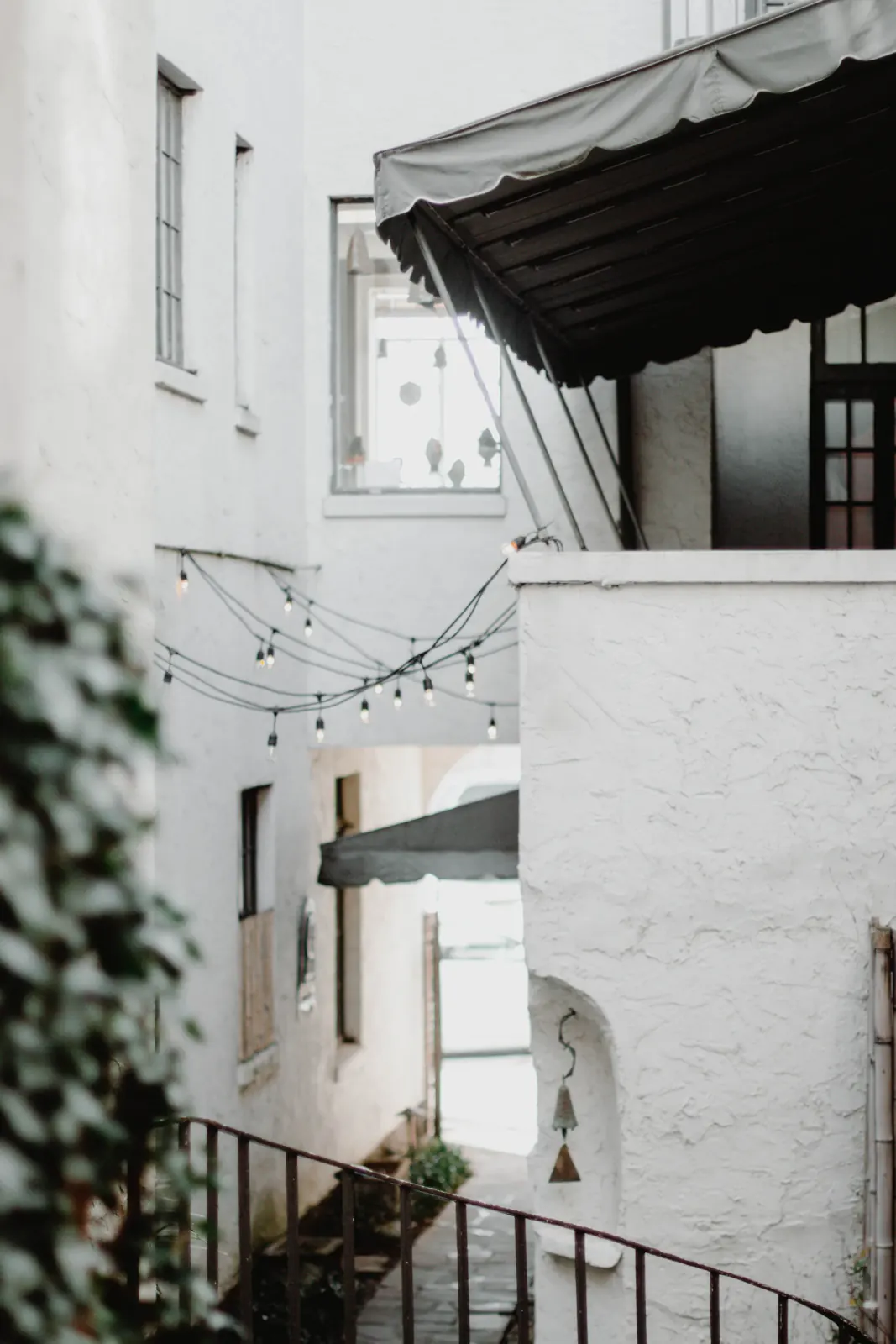 White stucco buildings, black awnings and string lights in a Chattanooga alley