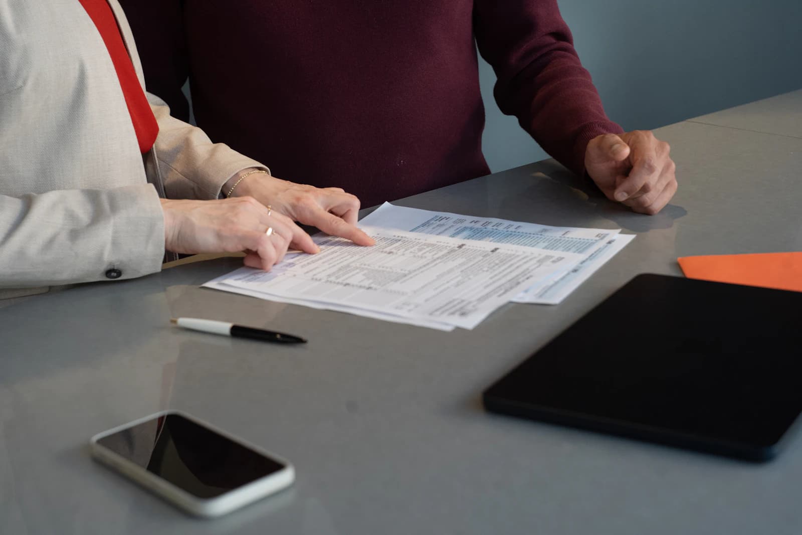 Two people reviewing paper documents together at a desk