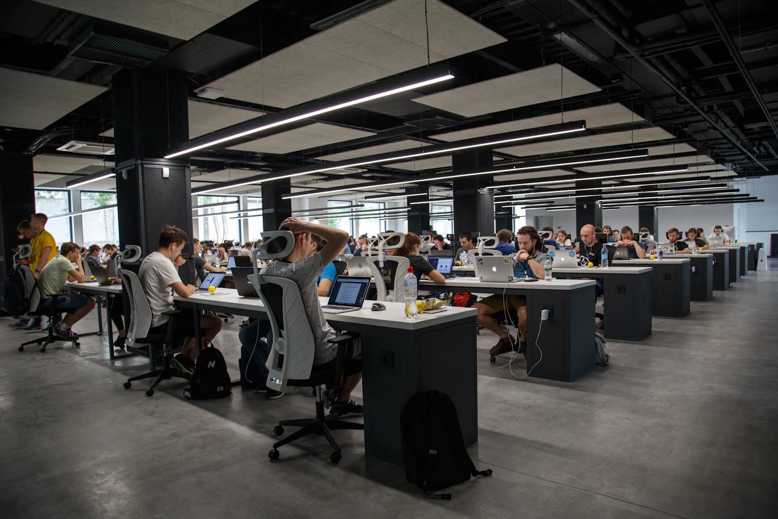People working at rows of desks in an open-plan office